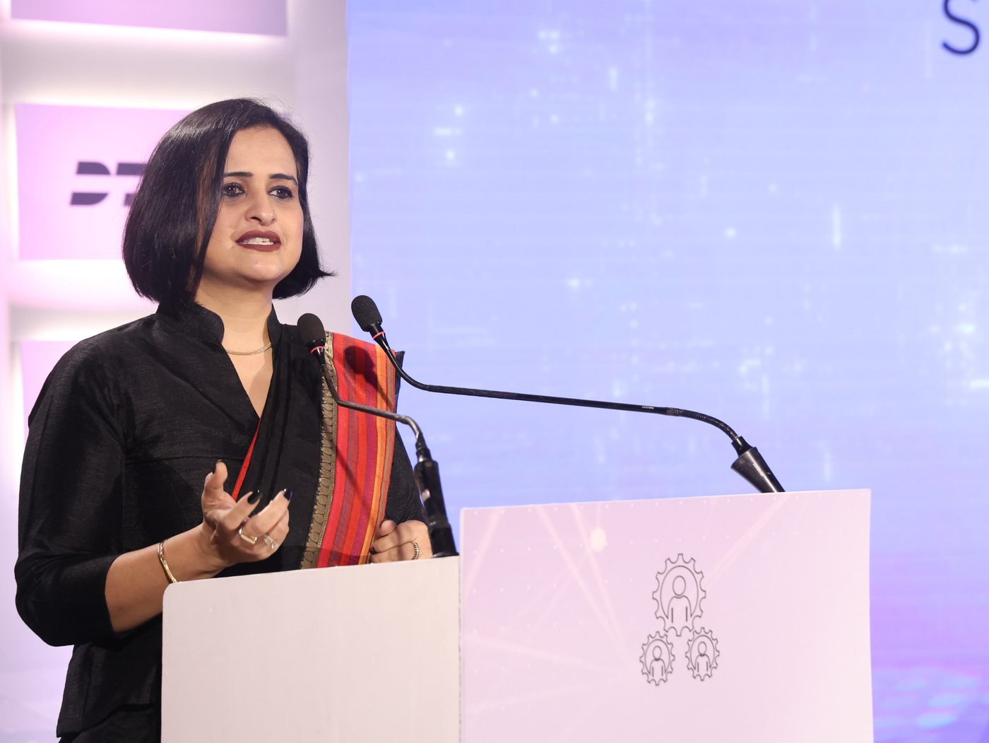 Mugdha Kalra delivering a keynote from the podium