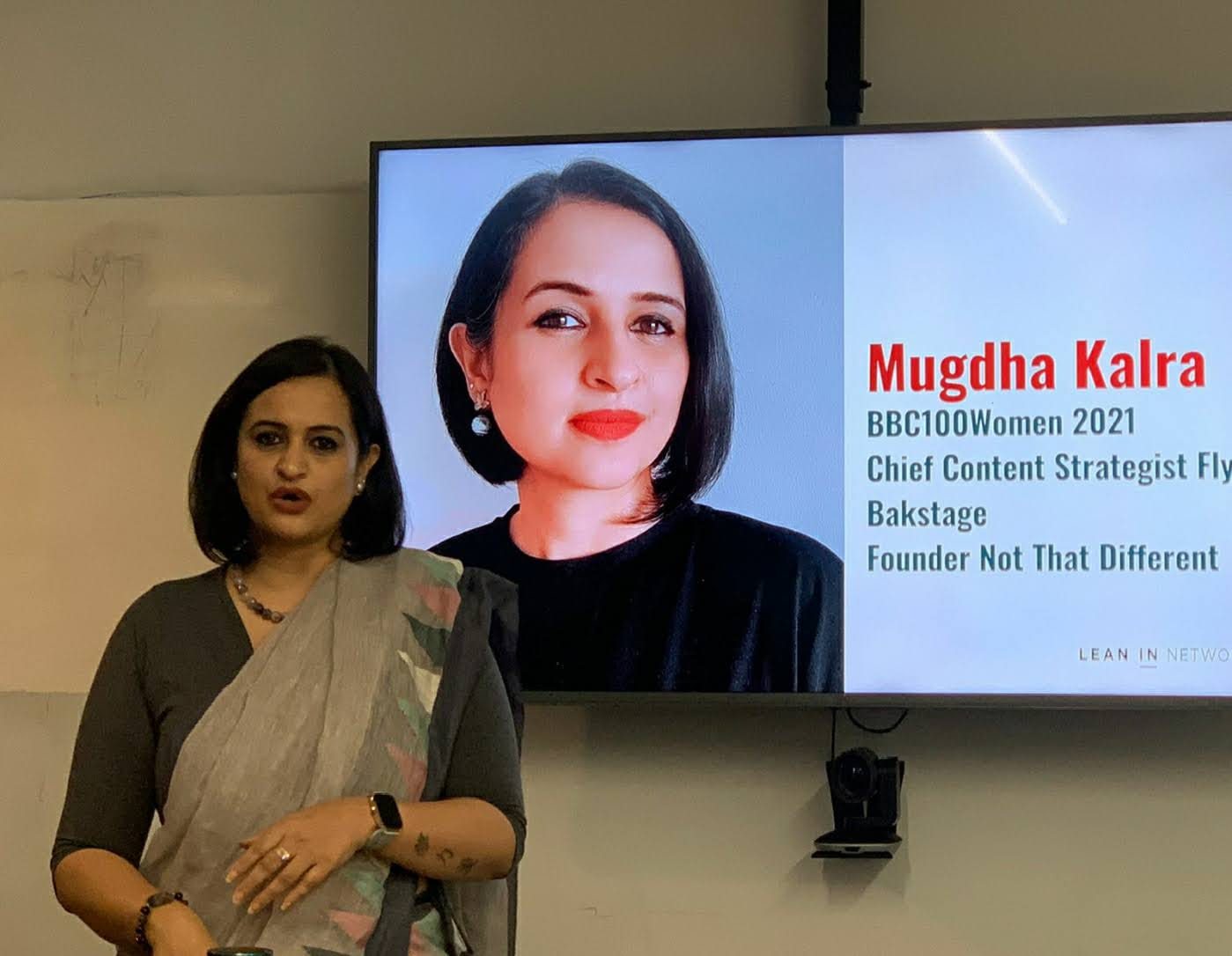 Mugdha Kalra presenting, with her BBC 100 Women slide